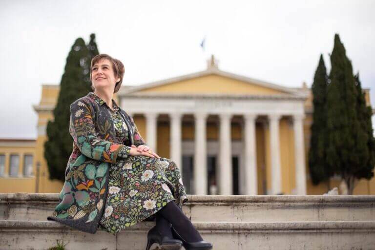 a solo female traveler in Athens Greece, is posing in front of Zappeion building